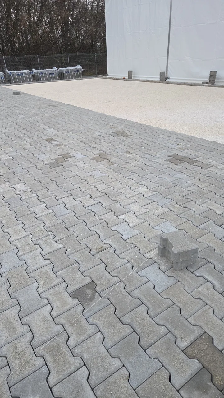 Szürke térkő és világos szemcsés udvarfelület találkozása